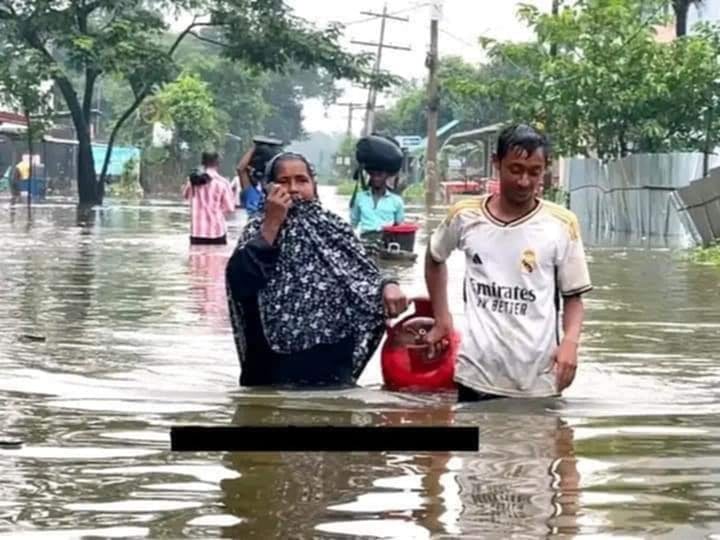বন্যার পানি ডিঙিয়ে রান্নার গ্যাসের সিলিন্ডার নিয়ে যাচ্ছে একটি পরিবার। আজ সকালে ফেনীর ফুলগাজীর বসন্তপুরে
